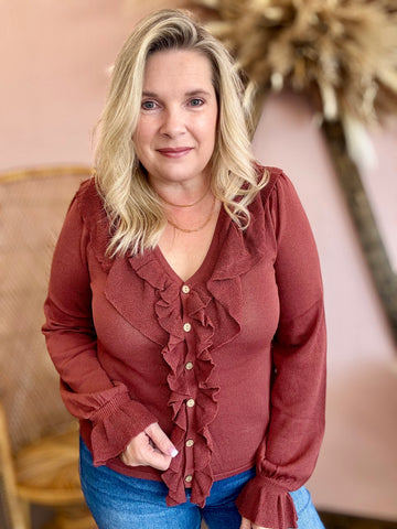 rust-colored blouse with ruffled details 