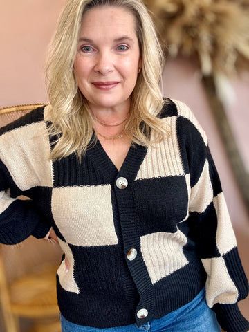 Woman wearing a black and beige checkered cardigan 