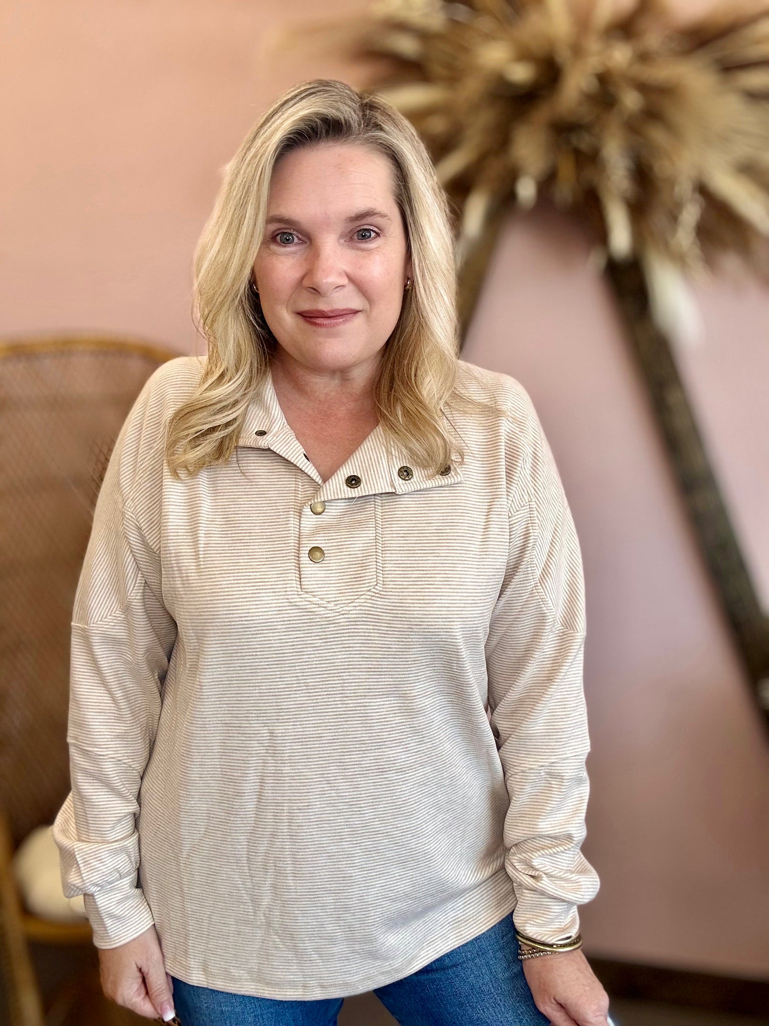 Woman wearing a beige long-sleeve shirt with buttons
