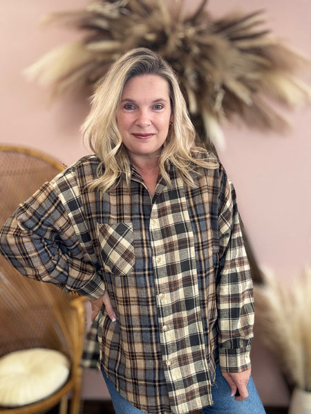 Woman wearing a plaid flannel shirt  with buttons. 