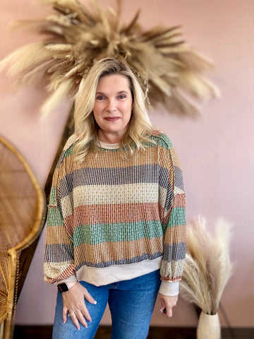 Woman wearing a colorful striped sweater.