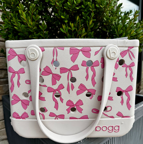 White handbag with pink bow pattern and 'bogg' branding.