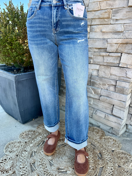 women wearing medium washed boyfriend jeans with some distressing. 