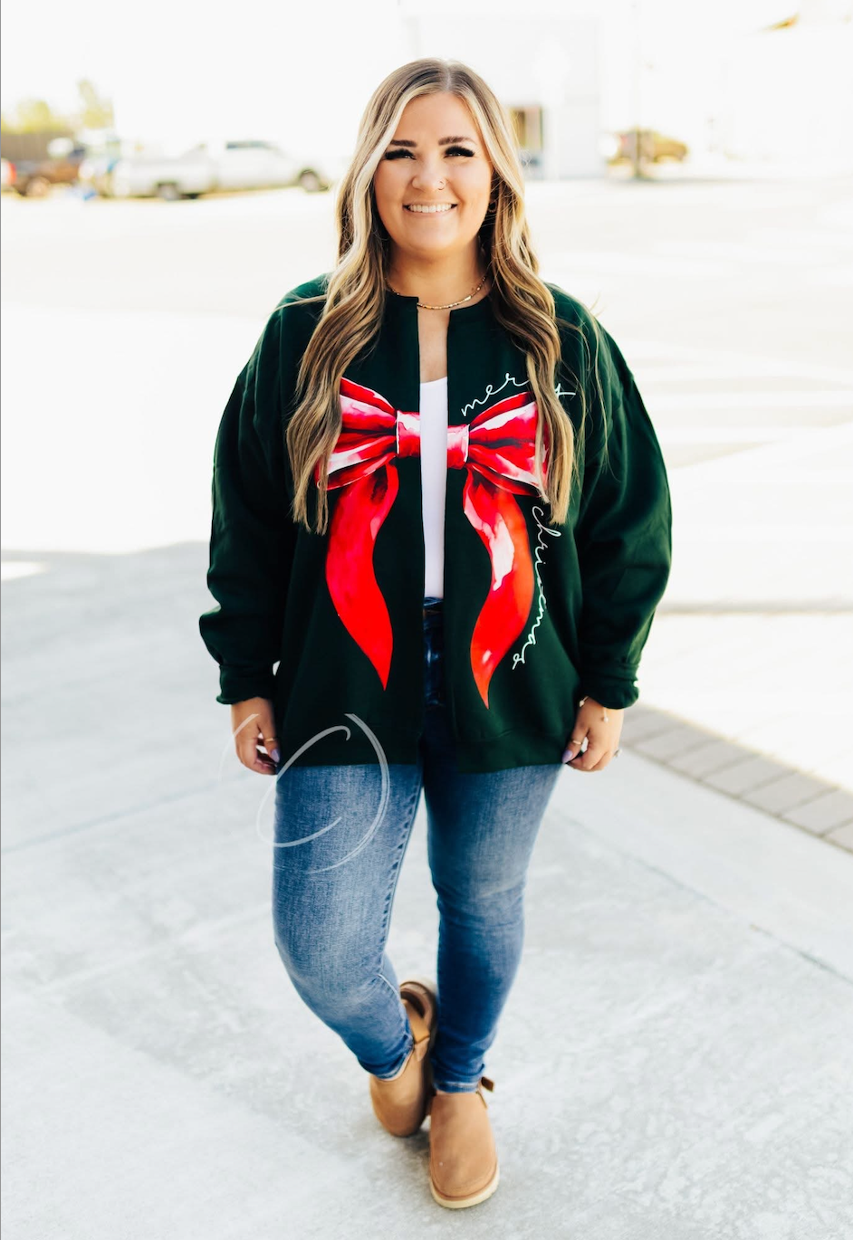 Woman wearing a green sweatshirt cardigan with a red bow design.